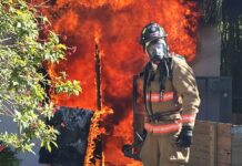 a firefighter standing in front of a fire