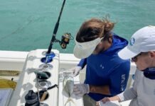 a man and a woman on a boat with a fishing rod