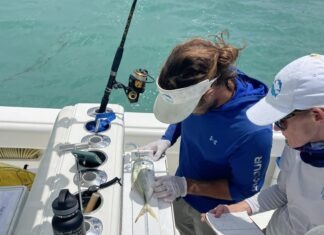 a man and a woman on a boat with a fishing rod