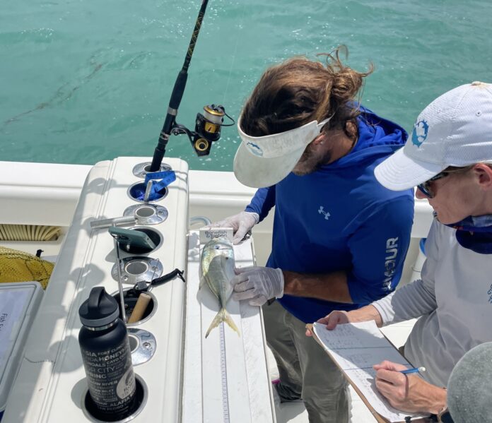 a man and a woman on a boat with a fishing rod