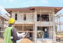 a man standing in front of a house under construction