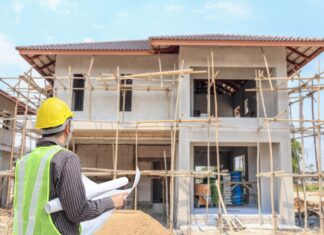 a man standing in front of a house under construction