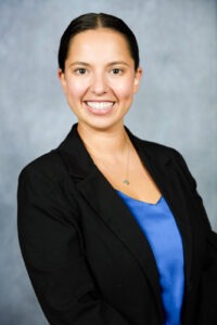 a woman in a black jacket and blue shirt