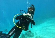 a man in a scuba suit is diving in the water