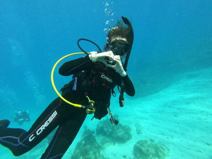 a man in a scuba suit is diving in the water