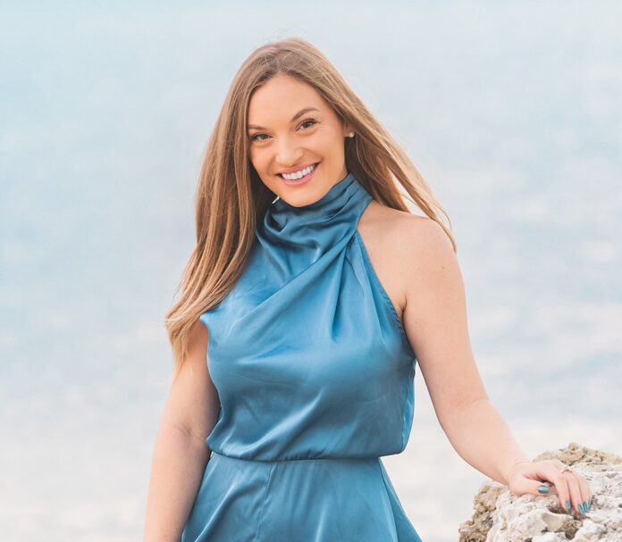 a woman in a blue dress holding a rock