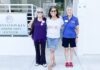 three women standing in front of a building