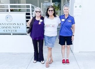 three women standing in front of a building