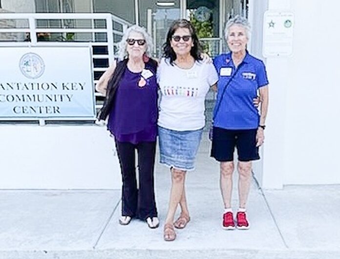 three women standing in front of a building