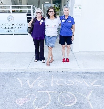 three women standing in front of a building
