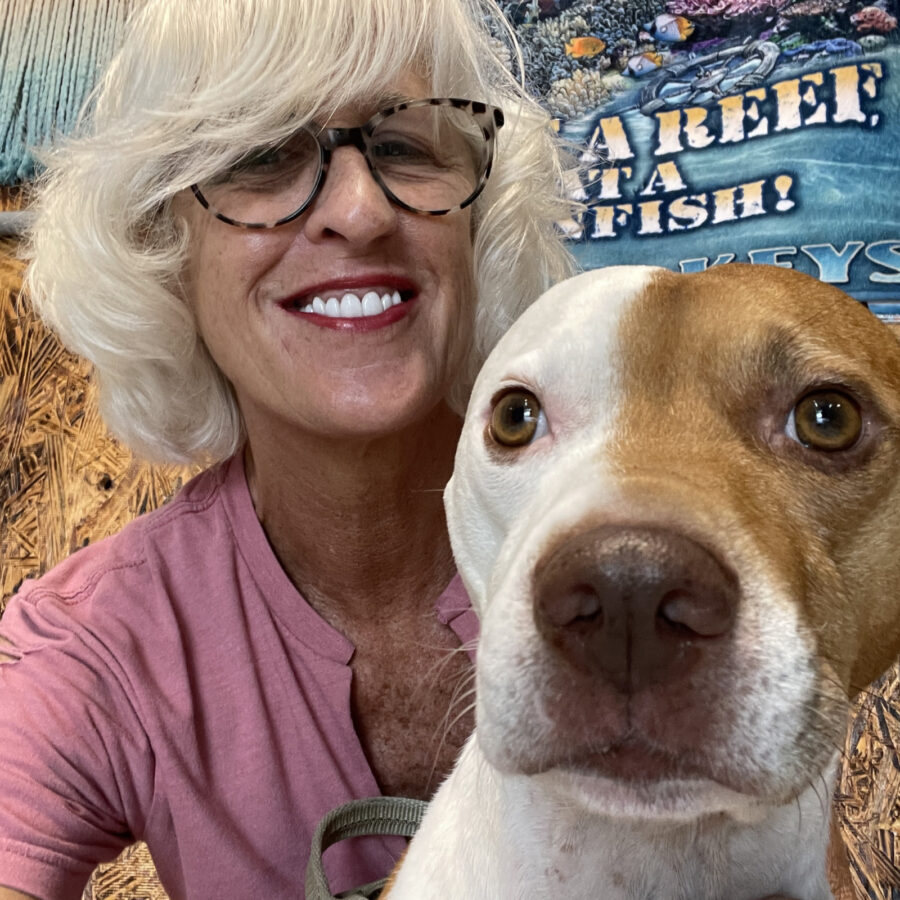 a woman holding a brown and white dog