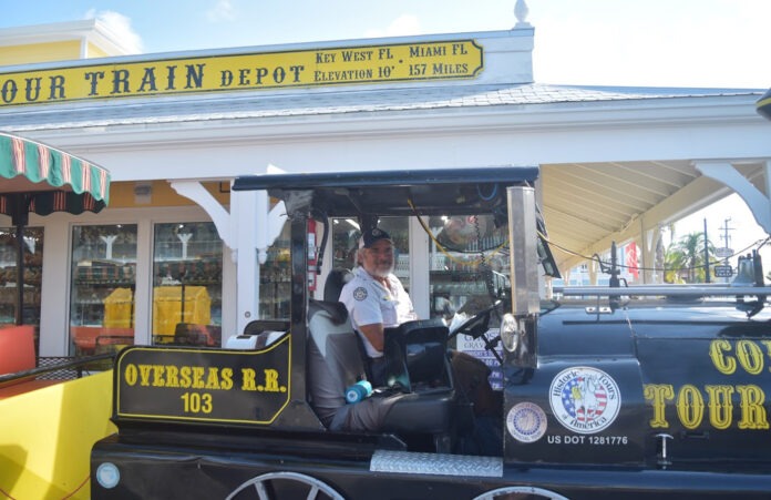 a man standing inside of a small train