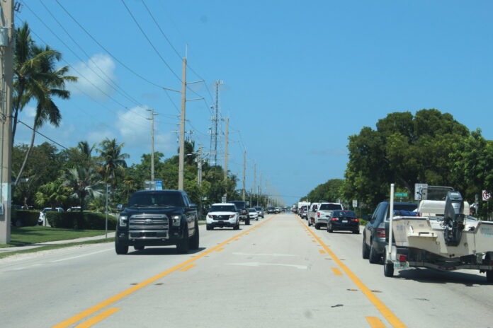 a street filled with lots of traffic next to palm trees