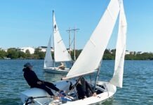 a couple of people on a sailboat in the water