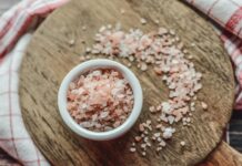 a bowl of sea salt on a wooden cutting board