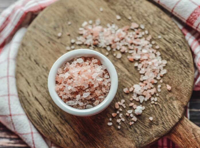 a bowl of sea salt on a wooden cutting board