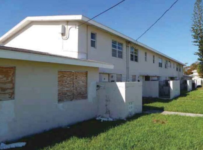 a row of houses with boarded up windows