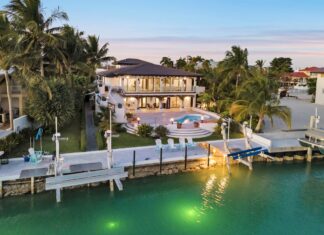 an aerial view of a waterfront home at dusk