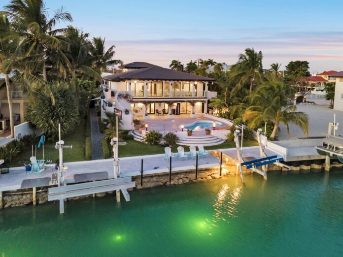 an aerial view of a waterfront home at dusk