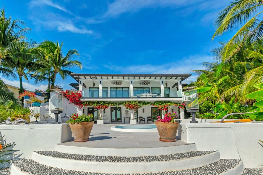 a white house with a pool in front of it