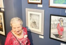 a woman standing in front of a wall with pictures on it