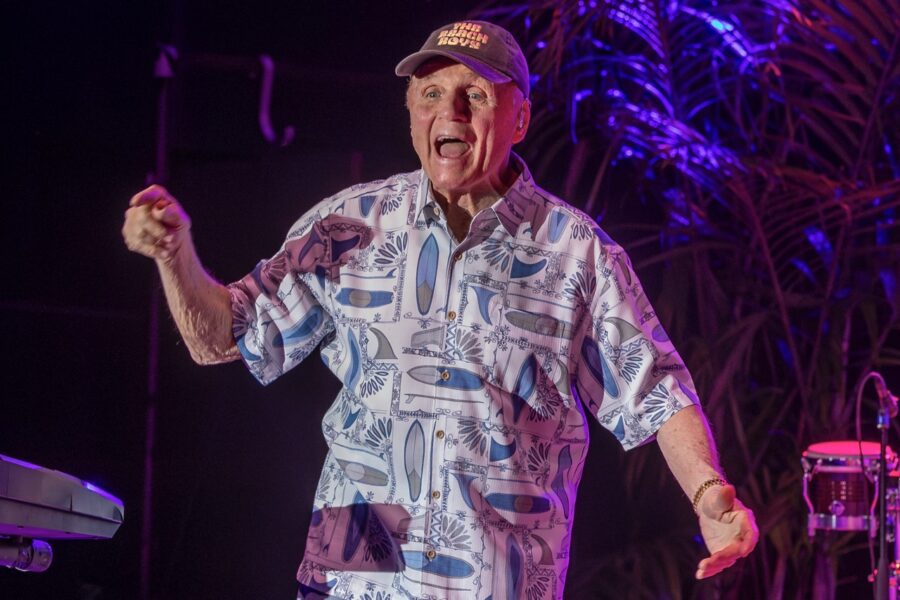 a man standing on a stage with his hands in the air