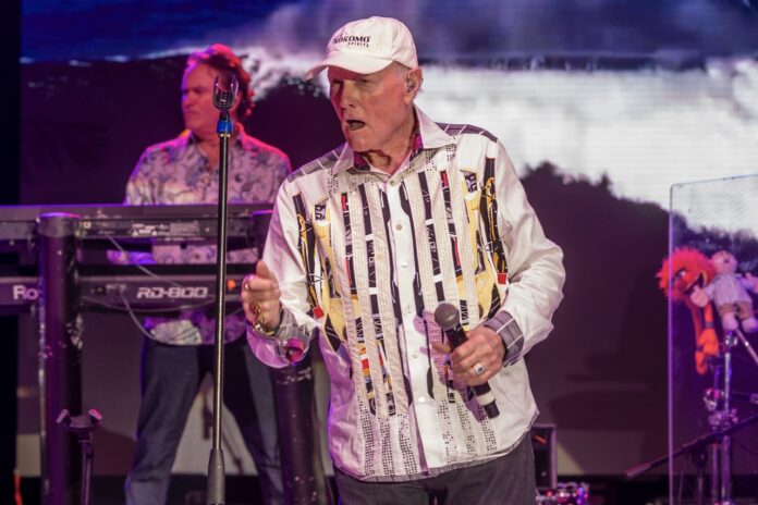 Beach Boys Mike Love Large a man standing on a stage holding a microphone