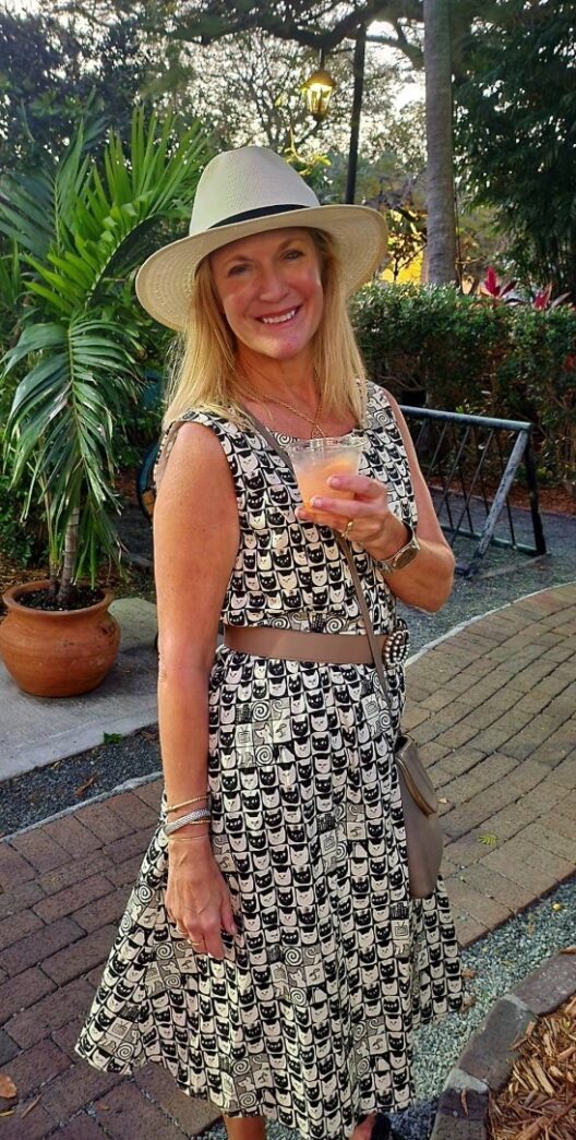 a woman in a hat holding a drink