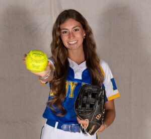 a woman in a baseball uniform holding a ball and glove