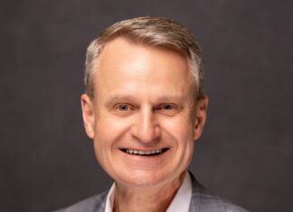 a man in a suit smiling at the camera