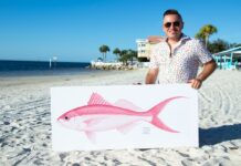 a man standing on a beach holding a sign