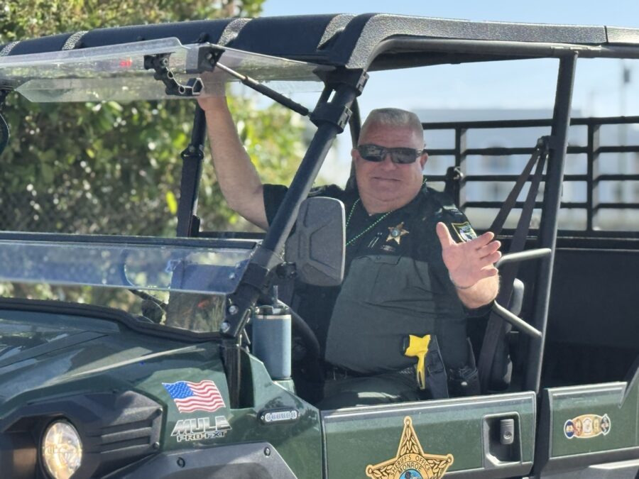 a police officer in a green jeep giving a thumbs up