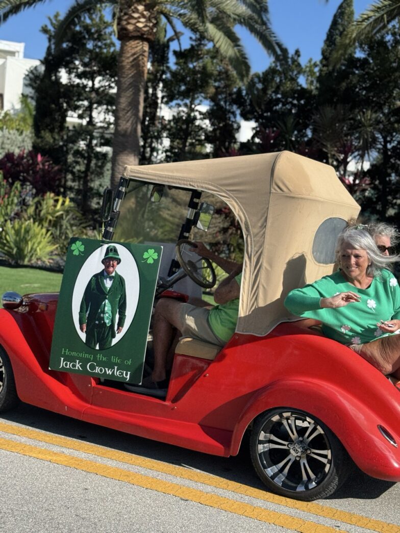 a man and a woman riding in a red golf cart