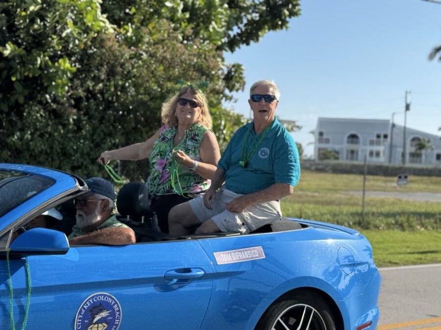 a man and a woman sitting in the back of a blue car