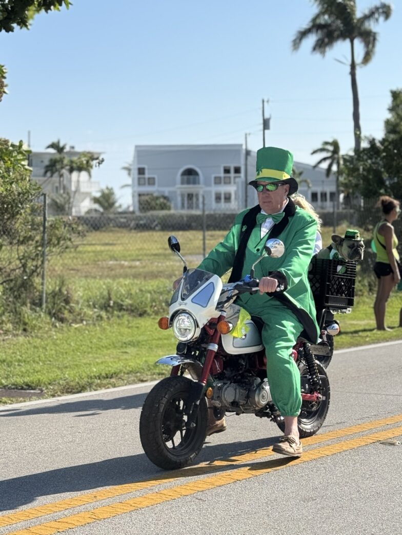 a man in a green suit riding a motorcycle