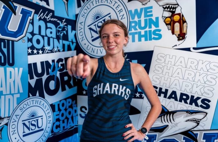 a woman standing in front of a wall covered in stickers
