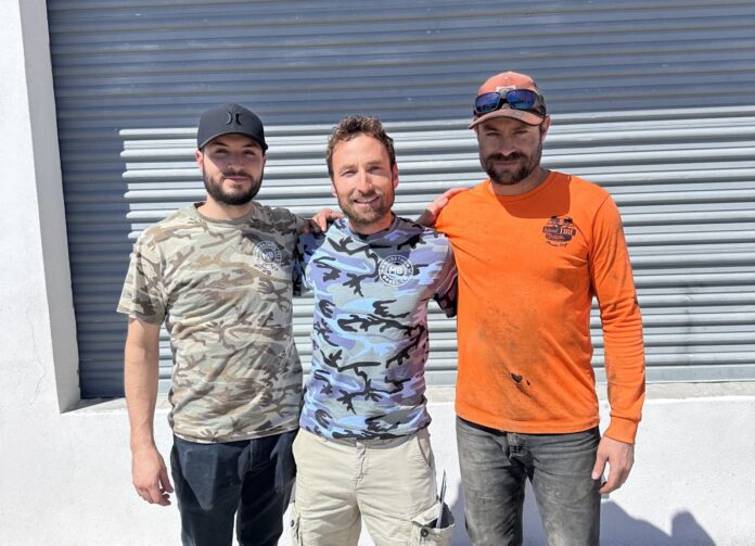 a group of three men standing next to each other