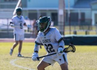 a lacrosse player holding a ball and a lacrosse stick