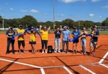 a group of people standing on top of a baseball field