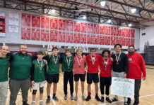 a group of young men standing on top of a basketball court