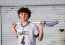 a young man holding a baseball bat and a glove