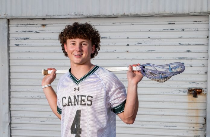 a young man holding a baseball bat and a glove