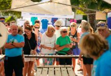 a group of people standing around a wooden table