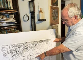 a man pointing at a map on a wall