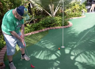 a man hitting a golf ball with a golf club