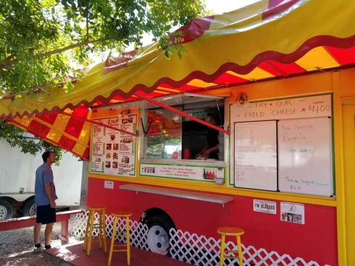 a man standing in front of a food truck