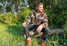 a man sitting on a log in the woods