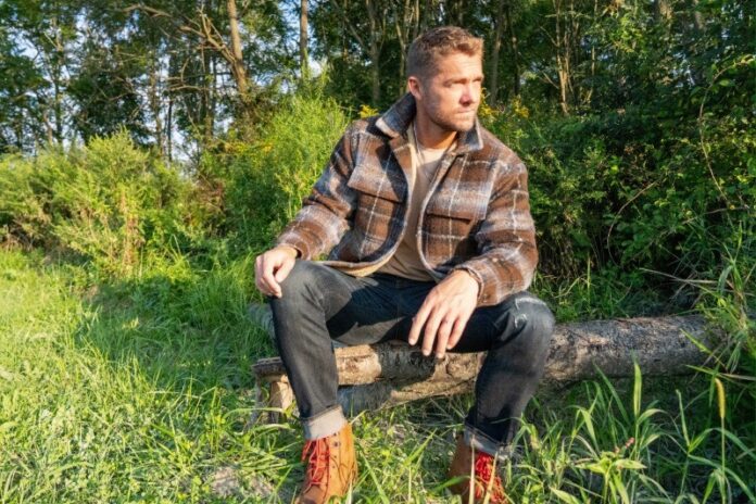 a man sitting on a log in the woods