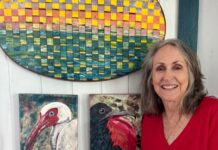 a woman standing in front of some paintings