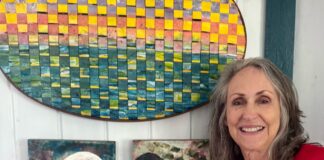 a woman standing in front of some paintings